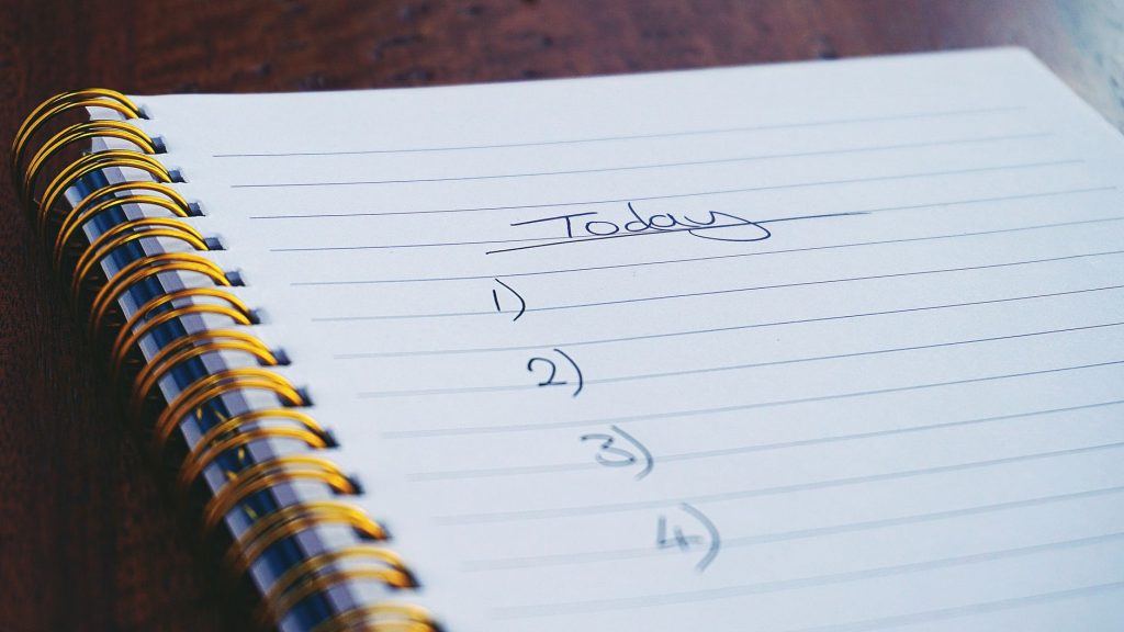 Bloc-notes et liste de tâches sur un bureau symbolisant les bonnes résolutions et l&rsquo;acrasie