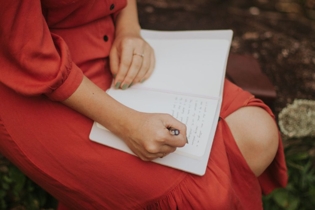 Personne écrivant ses valeurs et affirmations dans un carnet, au calme