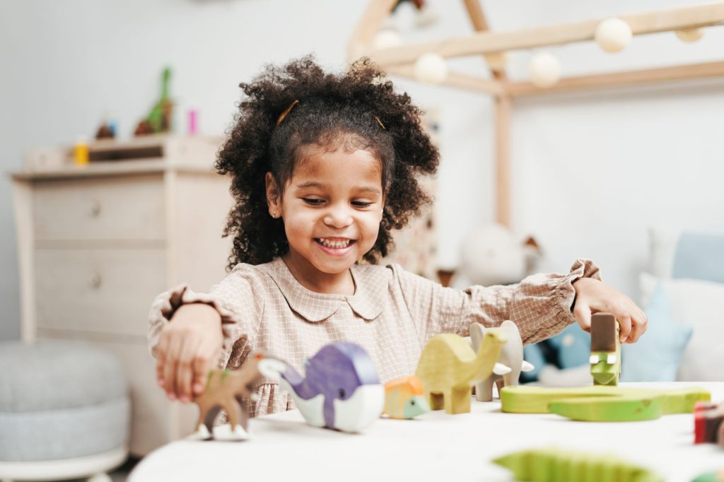 Jeune enfant jouant seul avec des jouets sur le sol