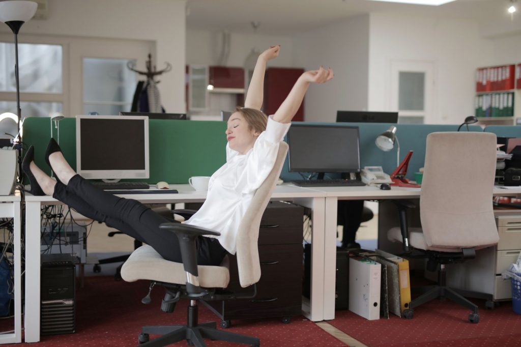 Personne s'étirant à son bureau pendant une micro-pause au travail