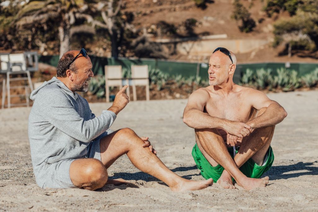 Deux amies discutent assises sur le sable, illustrant le langage du corps a la plage