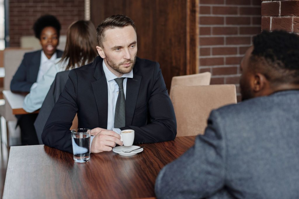 Deux personnes en pleine conversation attentive autour d’une table