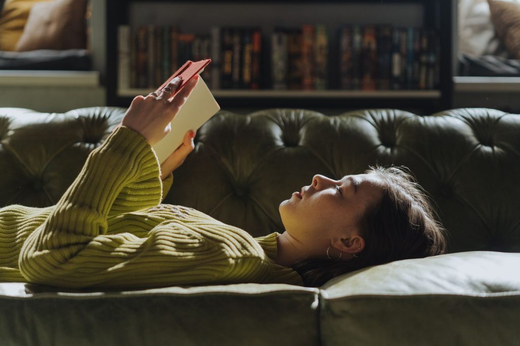 Femme lisant seule un livre dans un intérieur calme