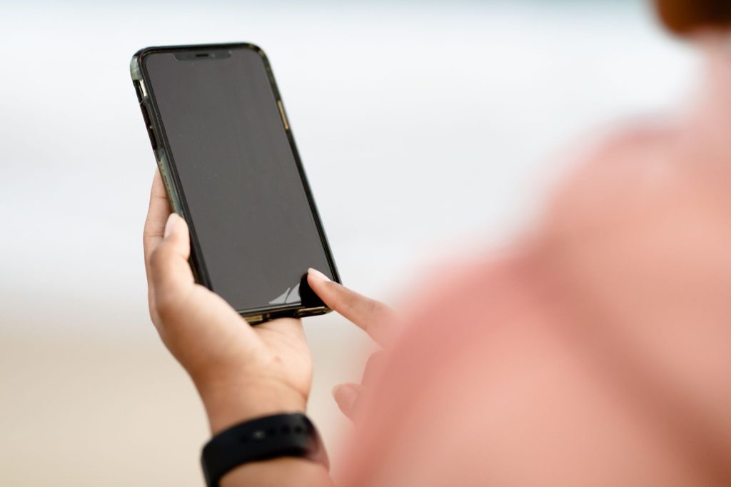Main tenant un smartphone, symbole de l'hyperconnexion qui comble l'ennui