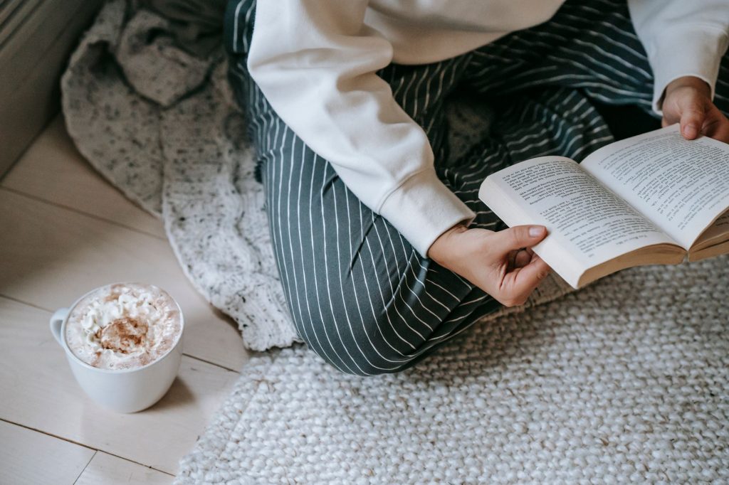 Personne lisant tranquillement chez elle avec un café