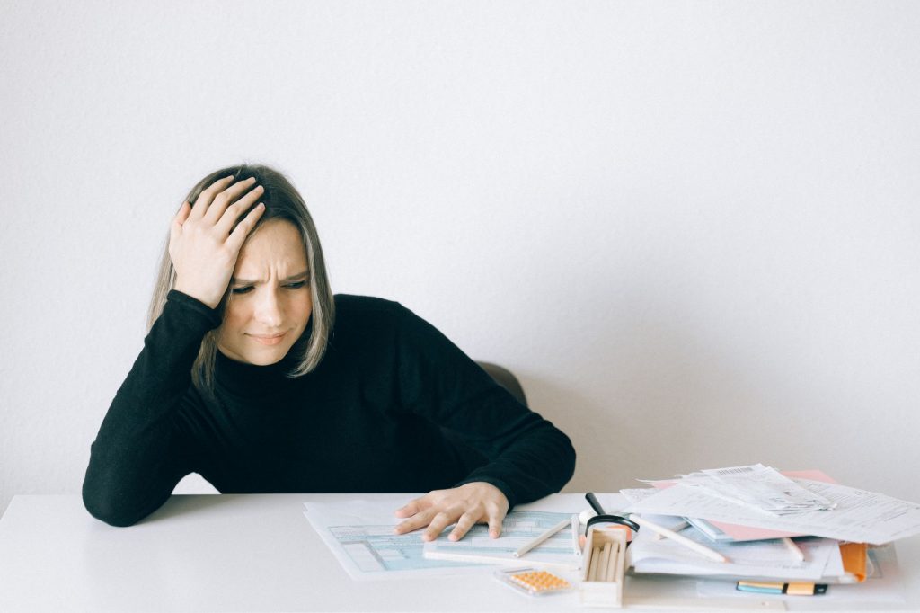 Femme épuisée et débordée au bureau, illustrant la charge mentale du people pleaser