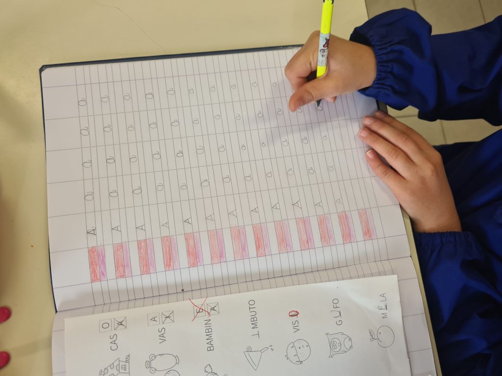 Un jeune enfant qui apprend à tracer ses premières lettres au crayon