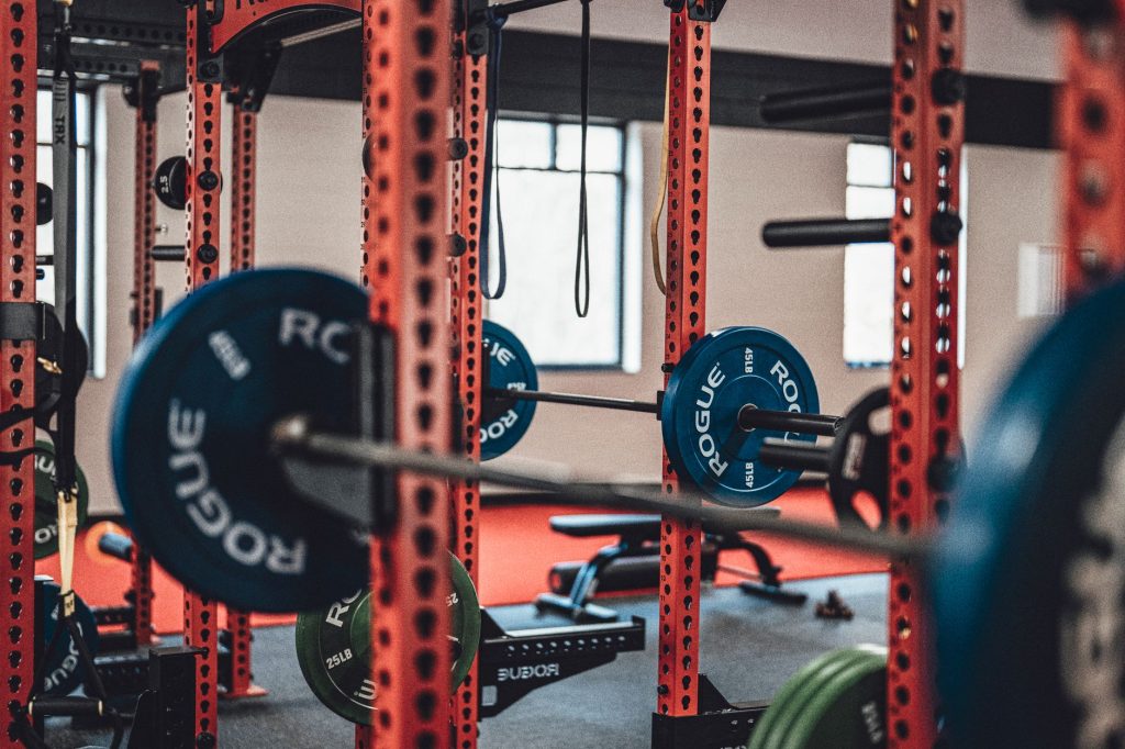 Pratiquant realisant une fente avec halteres en salle de musculation