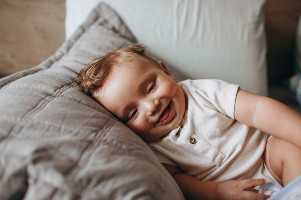 Bebe souriant, visage rond aux grands yeux