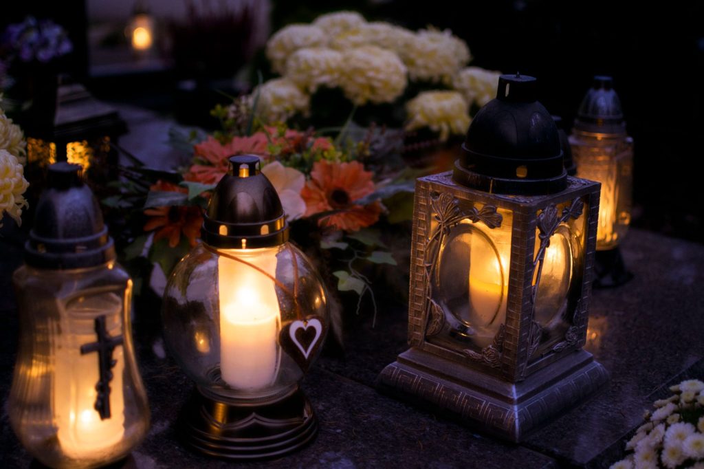Bougie allumée dans la pénombre, symbole de recueillement et de mémoire après un décès