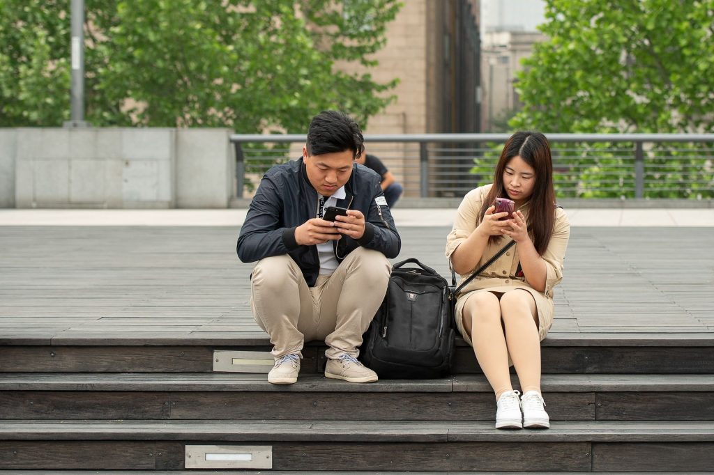 Deux partenaires absorbés par leur téléphone sans se regarder