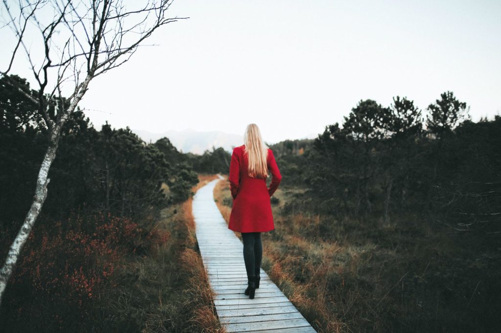Personne marchant seule sur un chemin forestier, image du cheminement lent du deuil