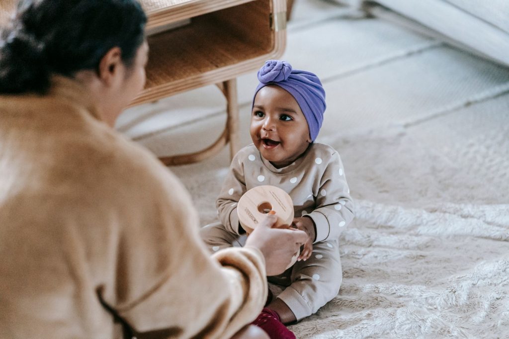 Un parent souriant joue en face à face avec son bébé