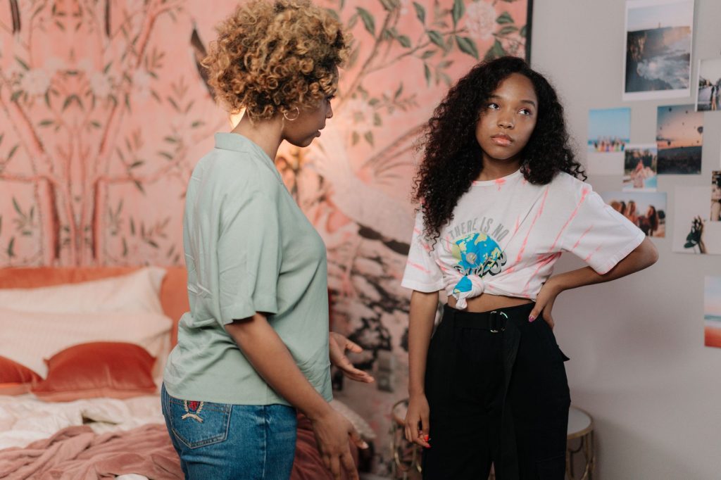 Une mère et son adolescent en pleine discussion tendue dans le salon