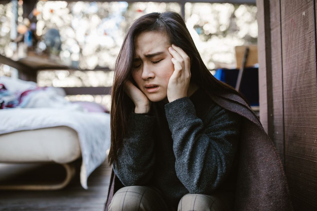 Femme se tenant la tête, prise de vertiges liés au stress et à l'anxiété