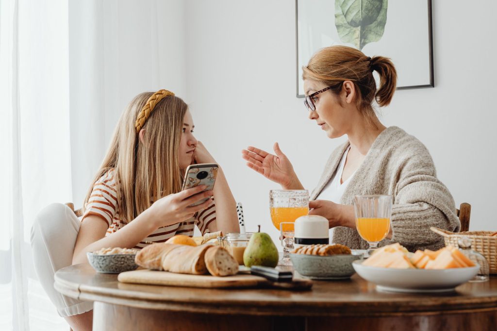 Famille discutant autour de la table de la cuisine avec leur adolescent