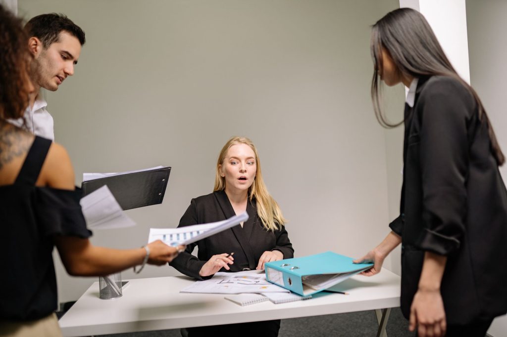 Groupe de collegues reunis autour d’une table de bureau avec des documents