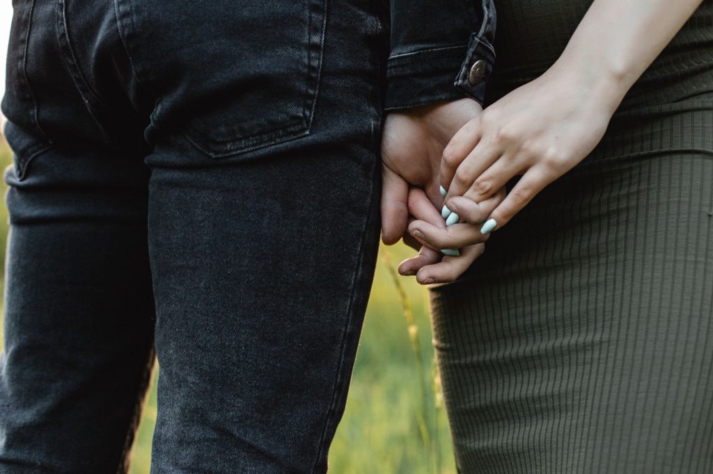 Couple se tenant la main en extérieur, symbole de confiance retrouvée