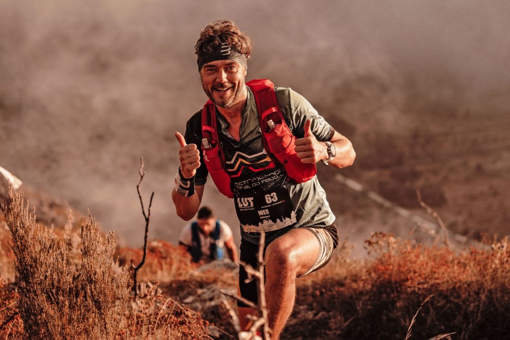 Coureur d'ultra-trail progressant sur un sentier de montagne