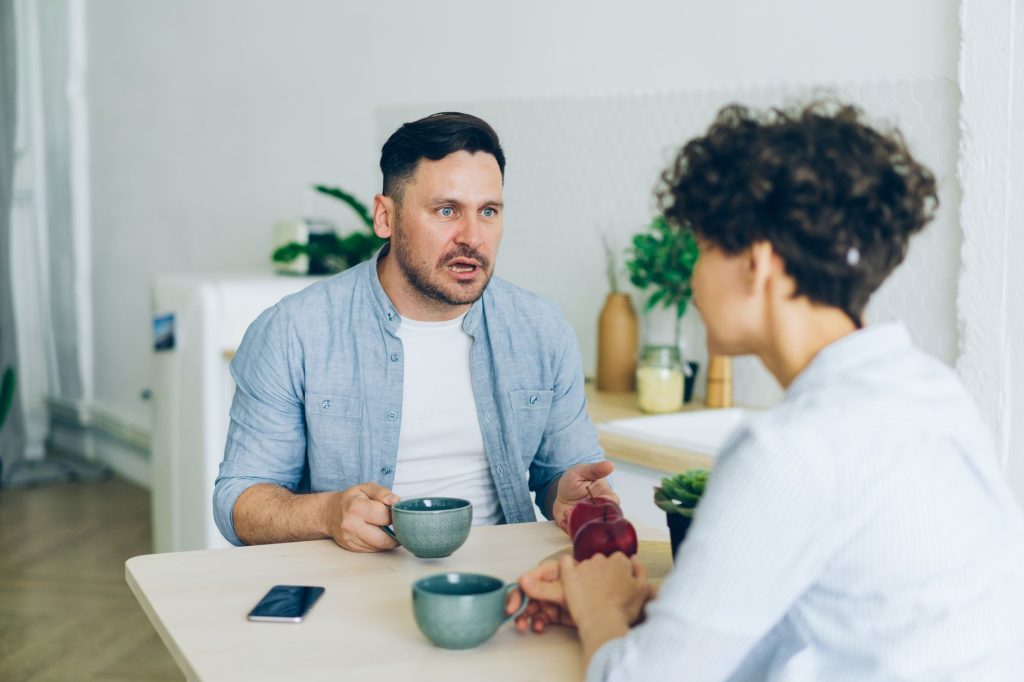 Un homme et une femme ont une conversation sérieuse, assis face à face