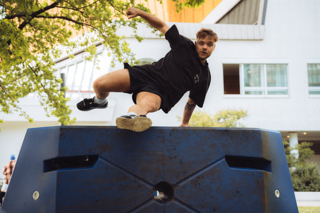 Traceur de parkour effectuant un saut acrobatique entre deux structures urbaines