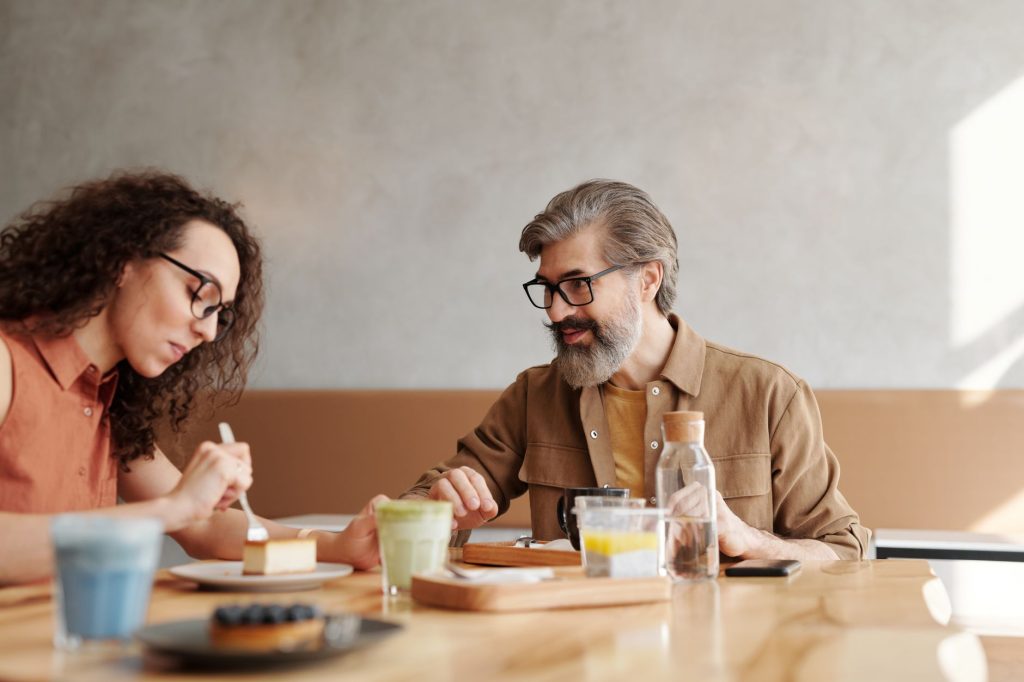 Un homme et une femme discutent autour d’un café, distance réduite et regards croisés