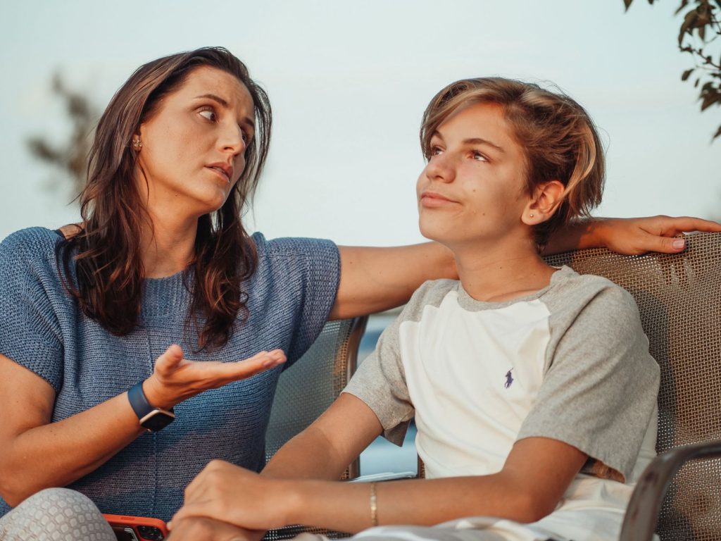 Un parent et un adolescent discutent côte à côte dans la cuisine