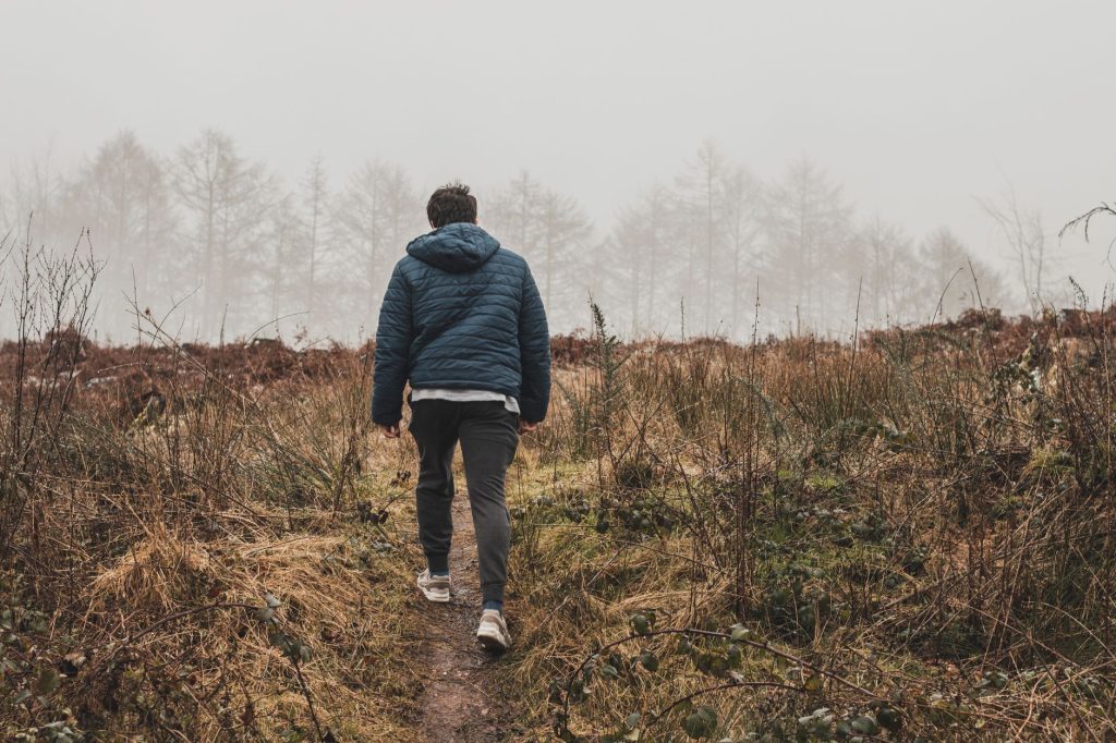 Homme marchant seul sur un chemin en forêt pendant une pause dans sa relation