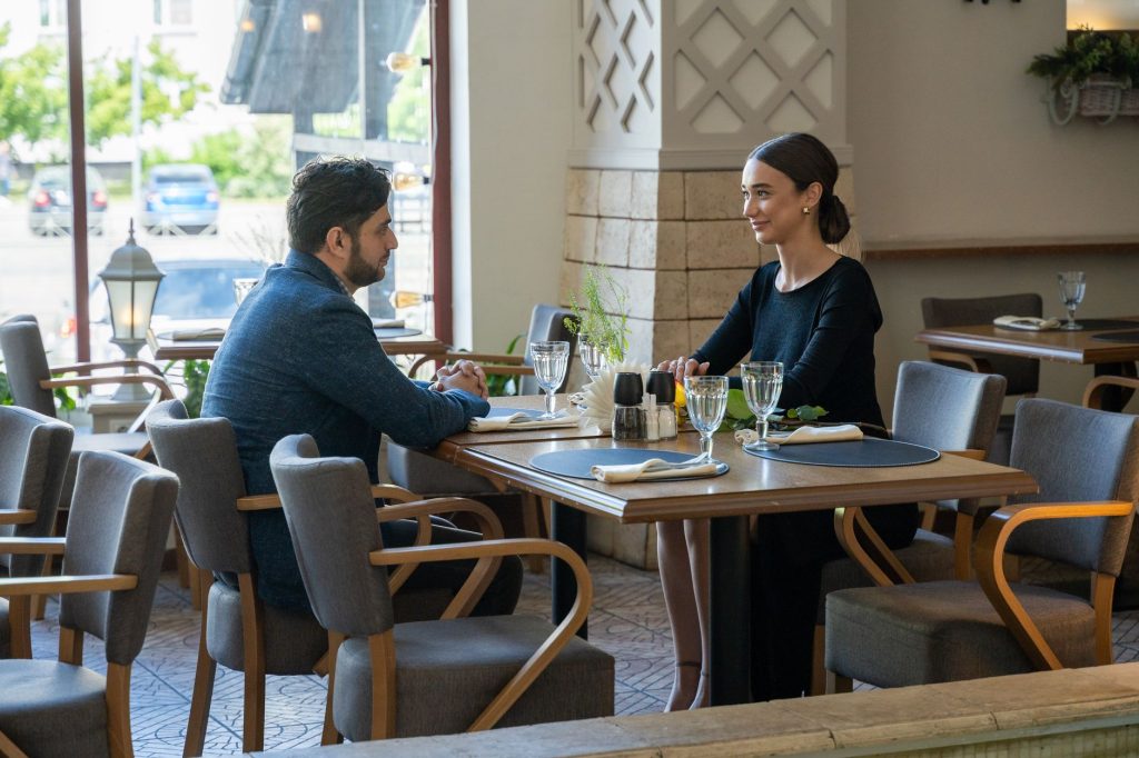 Un homme et une femme en pleine conversation attentive autour d’une table