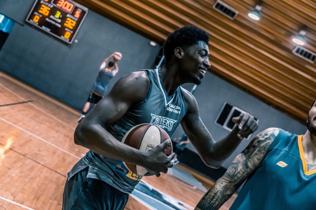 Joueurs de basket-ball à l'entraînement travaillant leur technique