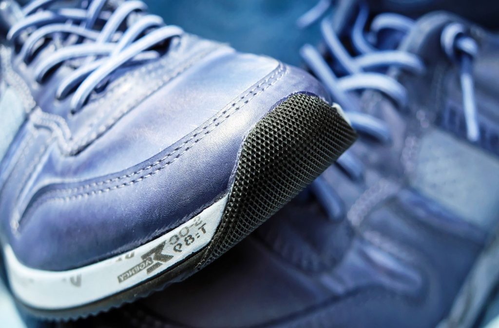 Chaussures de sport adaptees a la marche posees sur un chemin exterieur